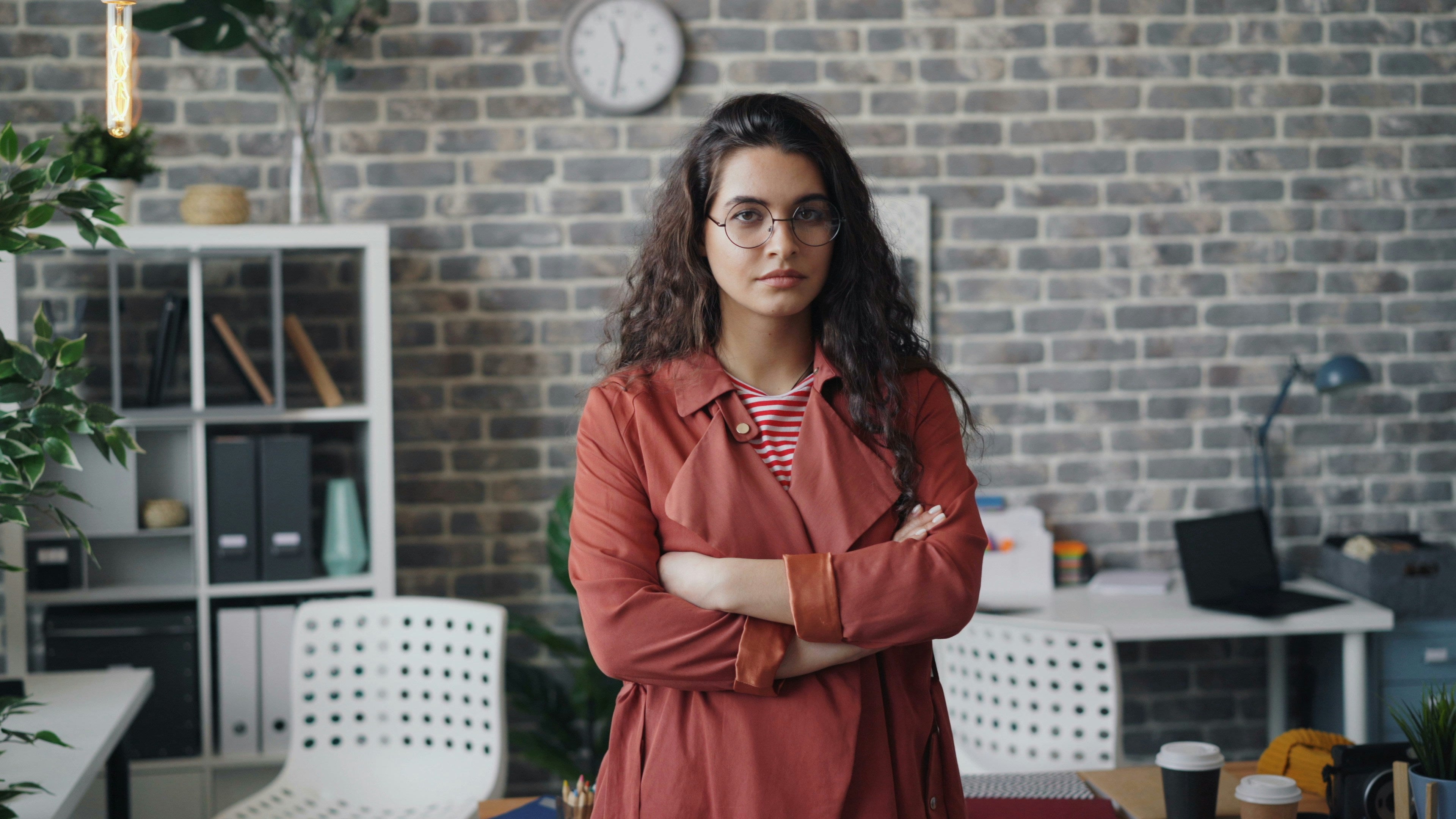 Frustrated woman with arms crossed in front of an office setup