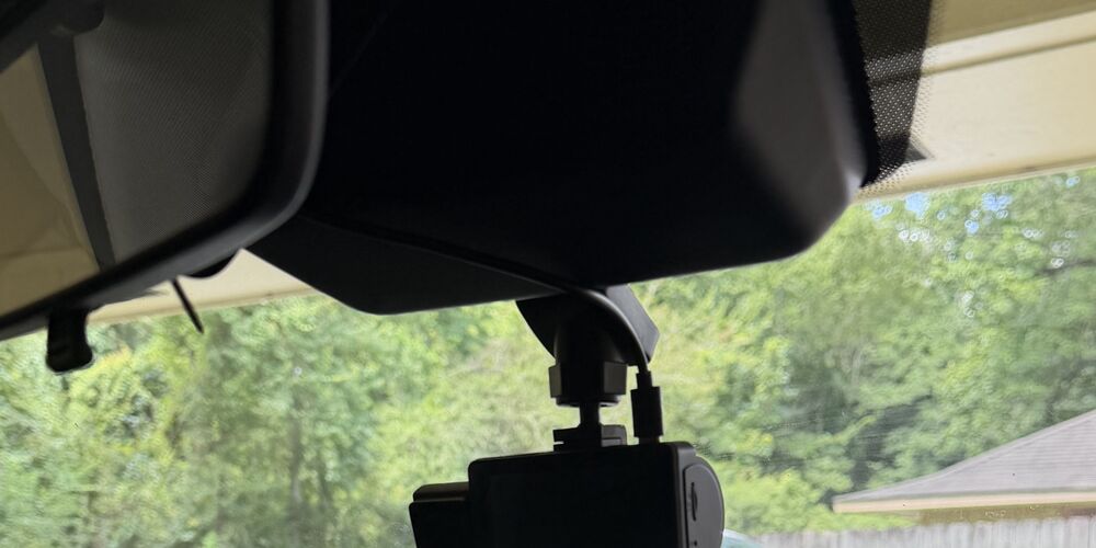 TruceVision camera mounted just below the rearview mirror, low enough that the mirror does not block the driver-facing lens